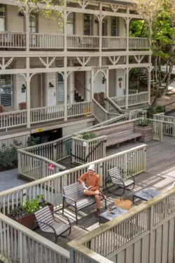 Veranda with wicker chairs, wooden railing, and trees surrounding the verandahMillValleyInn2025ShotByTheNomadicPeople-85.jpg