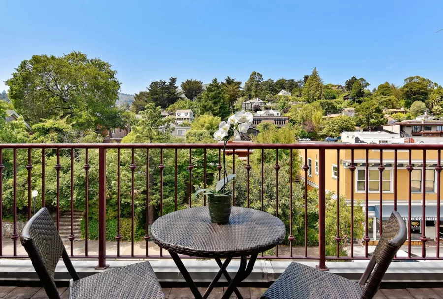 Small table and two chairs on balcony overlooking treetops of Mill Valley