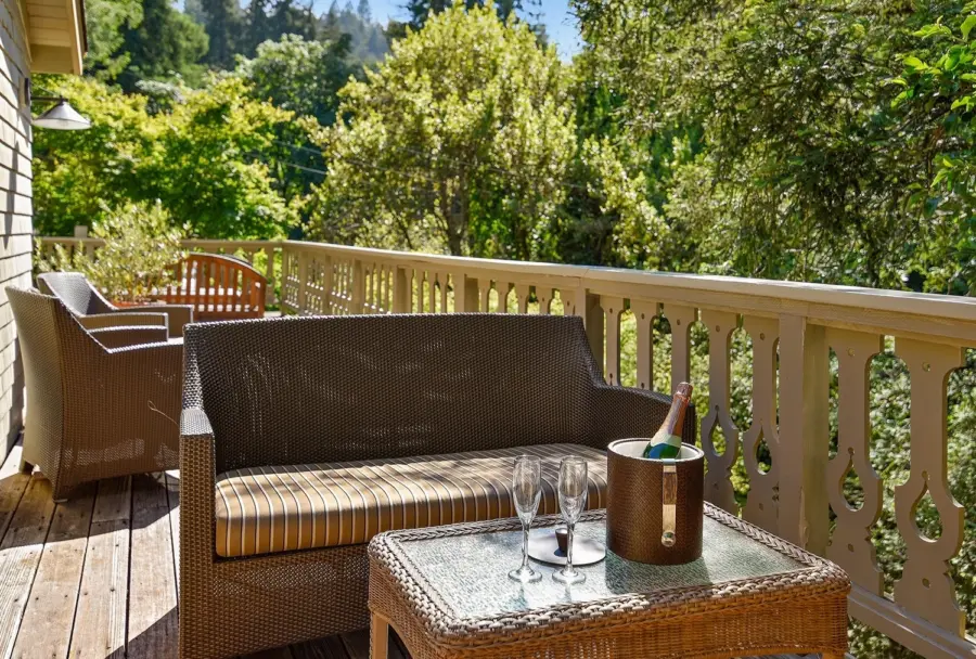 Wicker furniture on large deck with views of trees